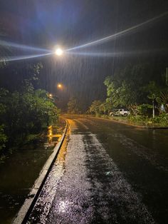 the street is flooded with water and it's lights shine brightly on the road