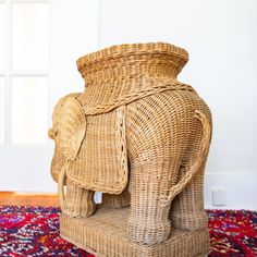 an elephant shaped basket sitting on top of a rug