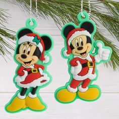 two mickey mouse christmas ornaments hanging from a tree