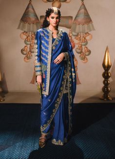 The neel bahar sari is a semi stitched sari that is paired with a contemporized version of a poncha (salwar). Adorned in delicate sitara embroidery with colorful applique patchwork adding splashes of colors as the eye travels the length of the ensemble. Paired with a optional long bandi jacket (optional), embellished with our house motifs- this grand attire is sure to stand out at any occasion. Jacket With Saree, Sari India, Applique Patchwork, Indian Embroidery, Indian Outfit, Indian Wedding Dress, Indie Fashion, Kaftan Dress, Saree Styles