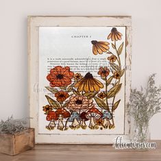 an old book page with flowers in it on a shelf next to a potted plant