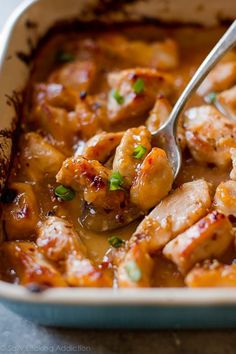 a spoon is in a casserole dish filled with chicken and gravy