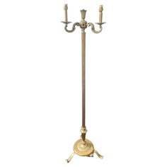 an antique brass plated three light candle stand with two candles on each side and one arm