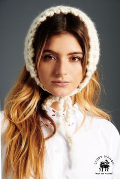 a woman with long hair wearing a white knitted hat and scarf over her head