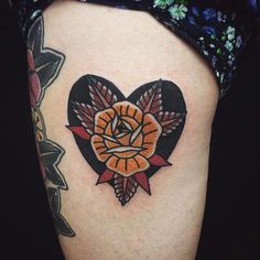 a heart shaped tattoo with an orange rose on it