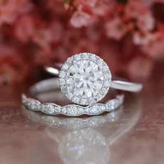 a close up of a diamond ring with flowers in the background