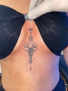 a woman's stomach with a tattoo on her back and hand in the background