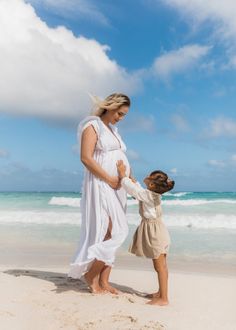 a woman and child standing on the beach