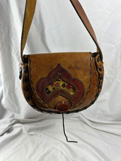 Measurements are 8" wide, 7"5 high, 1"5 deep with one 31"5 shoulder strap with a 13" drop.  On the interior there is one main compartment with a front flap closure. The leather on this purse is thick and strong with lovely hand tooled front along with front tapestry flap and brown leather weave. Bag is vintage and in fair to good condition with some water spots with no tears and will last you for years to come. Bag is one of a kind from the 1970s.  ----------------------------------------I SHIP Vintage Hand Tooled Tote Satchel, Vintage Style Hand Tooled Tote Satchel, Vintage Hand-tooled Tote Satchel, Vintage Hand Tooled Rectangular Saddle Bag, Vintage Saddle Bag With Removable Pouch, Artisan Hand Tooled Crossbody Saddle Bag, Vintage Rectangular Hand Tooled Saddle Bag, Vintage Hand-tooled Rectangular Saddle Bag, Artisan Hand Tooled Crossbody Satchel