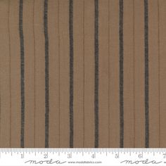 a ruler is next to a brown and black striped fabric that has stripes on it