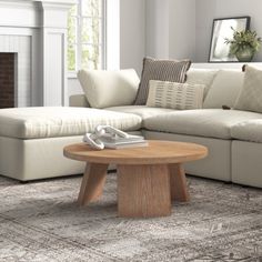 a living room with a couch, coffee table and fireplace in it's center