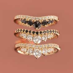 three gold rings with black and white diamonds