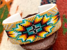 a beaded bracelet is sitting on top of a piece of wood