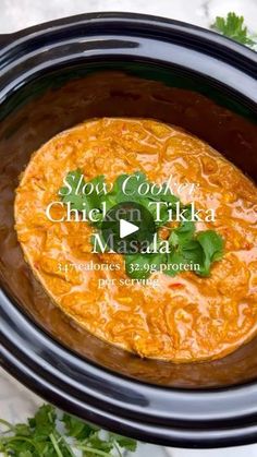 slow cooker chicken tikka masala in a crock pot with parsley on top