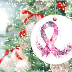 a pink ribbon ornament hanging from a christmas tree