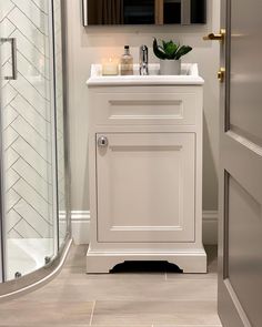 a bathroom with a sink, mirror and shower stall in the corner next to it