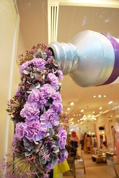 purple flowers hanging from the ceiling in a store