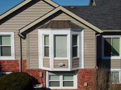 the front of a house with two windows on each side and one window in the middle