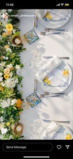 the table is set with white and yellow flowers