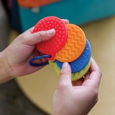 a person is holding three small toys in one hand and the other has a rubber disc on it