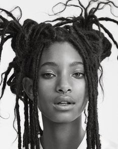 a black and white photo of a young woman with dreadlocks on her head