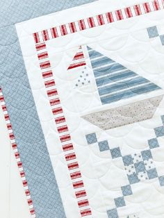 a close up of a quilt on a table with a red, white and blue design