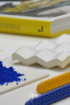 some blue and yellow legos are sitting on a table next to a book,