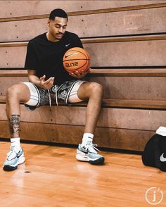 a man sitting on a bench holding a basketball