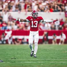 a football player with his arms outstretched on the field