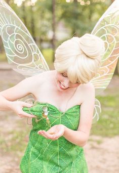 a woman dressed as a leaf fairy holding a bug