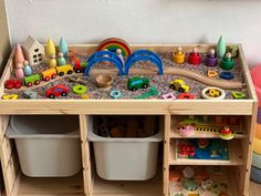 a child's play table with toys and storage bins