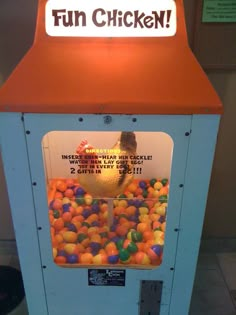 an orange and blue machine with lots of balls in it that says fun chicken on the front