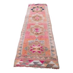 an orange and pink runner rug with geometric designs on the bottom, in different colors