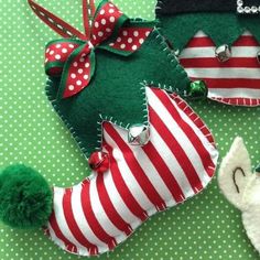 three christmas ornaments are sitting on a green tablecloth with white polka dots and red stripes