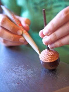 a person is holding a wooden object on a table