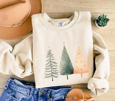 Stay cozy and festive with this minimalist Christmas tree sweatshirt. Perfect for the holiday season, this sweatshirt is made with a medium-heavy cotton-polyester blend, providing warmth and comfort. The classic fit and crew neckline offer a clean-cut style, while the double-needle stitching ensures durability. Ideal for those looking for a comfy and stylish option for cold winter days. Product features - Minimalist Christmas tree design - Made with a 50% cotton, 50% polyester blend - Classic fit with crew neckline - Ethically grown US cotton - Durable double-needle stitching Care instructions - Machine wash: cold (max 30C or 90F) - Non-chlorine: bleach as needed - Tumble dry: low heat - Do not iron - Do not dryclean Nature Inspired Christmas, Forest Christmas, Christmas Tree Sweater, Minimalist Christmas Tree, Tree Sweater, Womens Christmas Shirts, Christmas Tree Shirt, Minimalist Christmas, Group Shirts