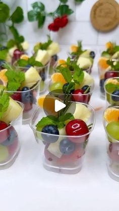 small cups filled with fruit and vegetables on top of a table