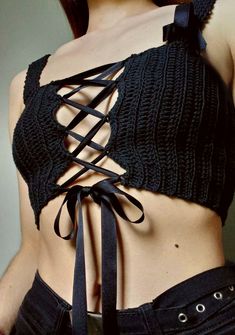 a close up of a woman wearing a black top with laces on it's back