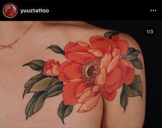 a woman's back with a flower tattoo on it