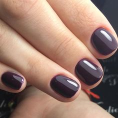 a woman's manicured nails with purple and black nail polish on top of it