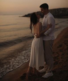 a couple kissing on the beach at sunset