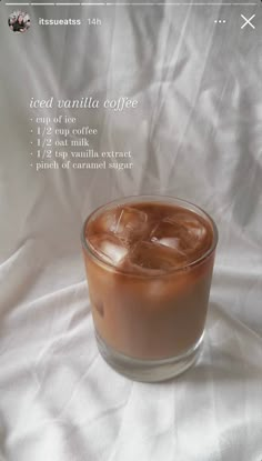 a glass filled with ice sitting on top of a white sheet