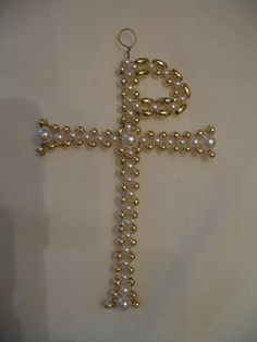 a cross made out of pearls on a white surface