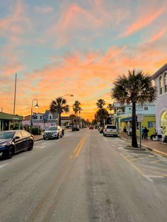 cars parked on the side of a street at sunset