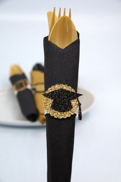 black and gold napkins are sitting on a white plate