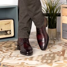 a man in brown pants and red shoes standing next to a radio