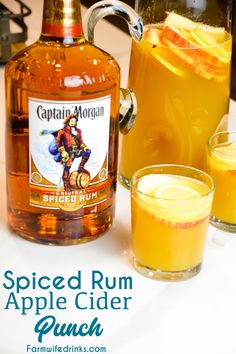 spiced rum apple cider punch is served in front of two glasses and pitcher