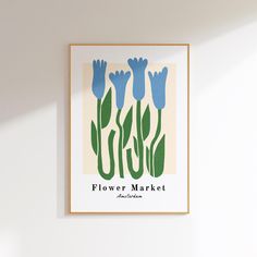 a white wall with a blue flower market poster hanging on it's side next to a window