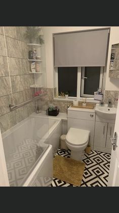 a bathroom with a toilet, sink and bathtub next to a window in it