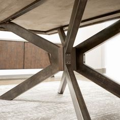 a close up of a metal table on a carpeted floor with white walls in the background